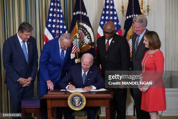 President Joe Biden signs the Inflation Reduction Act of 2022 into law during a ceremony in the State Dining Room of the White House in Washington,...
