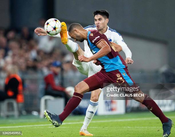Copenhagen's Dutch defender Kevin Diks and Trabzonspor's Brazilian defender Vitor Hugo vie during the play off Champions League football match FC...