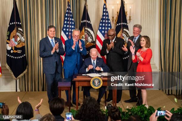 President Joe Biden, center, flanked by Sen. Joe Manchin , Senate Majority Leader Chuck Schumer , House Majority Whip Jim Clyburn , Rep. Frank...