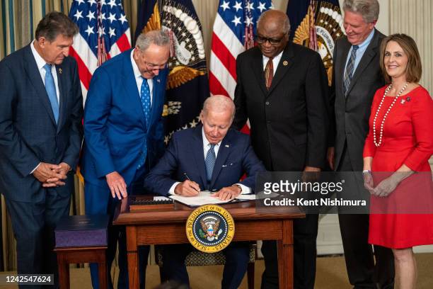 President Joe Biden, center, flanked by Sen. Joe Manchin , Senate Majority Leader Chuck Schumer , House Majority Whip Jim Clyburn , Rep. Frank...