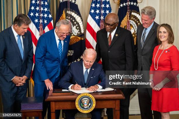 President Joe Biden, center, flanked by Sen. Joe Manchin , Senate Majority Leader Chuck Schumer , House Majority Whip Jim Clyburn , Rep. Frank...