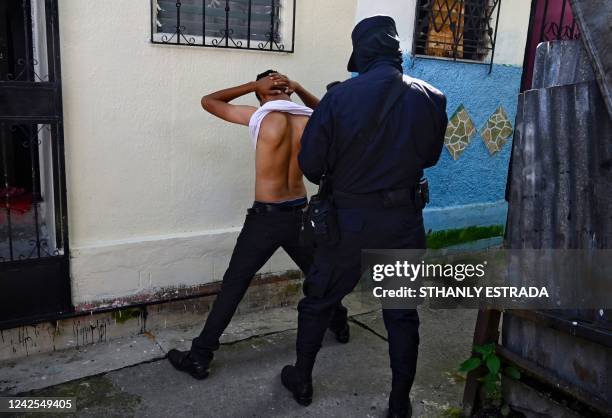 Police officer questions a young man during a security operation against gang violence in Soyapango, just east of the capital San Salvador, on August...