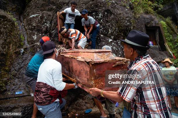 This picture taken on August 16, 2022 shows members of the Toraja ethnic group exhuming bodies of their relatives from a community burial site, to be...