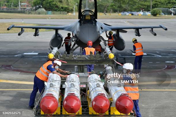 Air Force soldiers prepare to load US made Harpoon AGM-84 anti ship missiles in front of an F-16V fighter jet during a drill at Hualien Air Force...