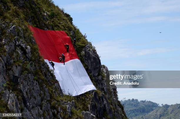 Environment activists raise the Indonesian flag with a length of 77 meters around the tallest Jesus statue in the world with a height of 1,700 meters...