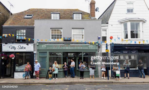 People wait for a public bus outside independent stores in Whitstable, UK, on Tuesday, Aug 16, 2022. Inflation, which is at...