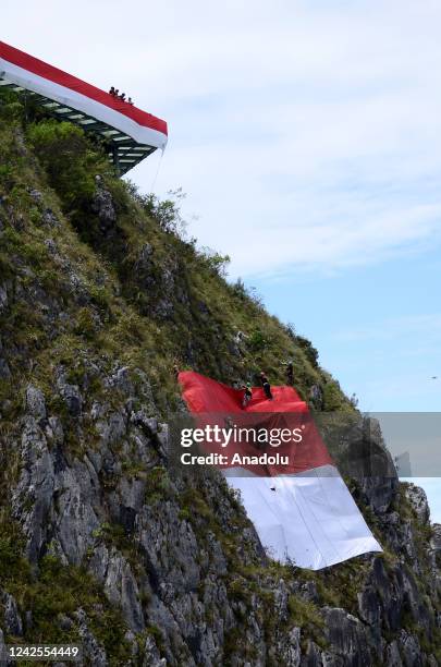 Environment activists raise the Indonesian flag with a length of 77 meters around the tallest Jesus statue in the world with a height of 1,700 meters...