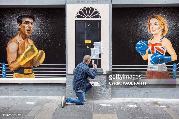 Artist Ciaran Gallagher puts the finishing touches to a new mural in Belfast city centre , depicting contenders to become the country's next Prime...