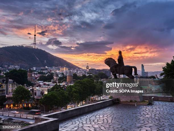 Sunset view towards Tbilisi old town and Statue of King Vakhtang Gorgasali from Metekhi St. Virgin Church. Tbilisi is the capital and the largest...