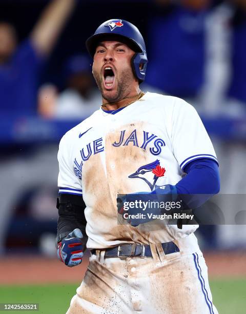 George Springer of the Toronto Blue Jays celebrates after scoring a run on a double by Santiago Espinal in the seventh inning against the Baltimore...