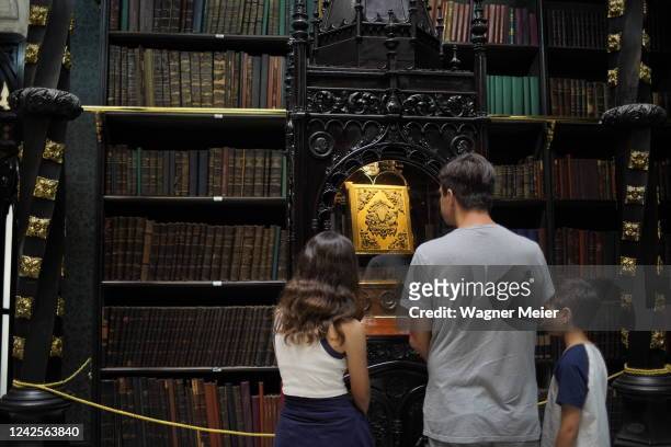 Tourists look a displayed honor book of Eduardo Lemos inside of the Royal Portuguese Cabinet of Reading on August 5, 2022 in Rio de Janeiro, Brazil....