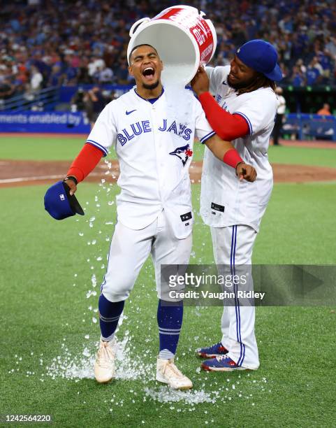 Santiago Espinal of the Toronto Blue Jays is doused with water by Vladimir Guerrero Jr. #27 following the win over the Baltimore Orioles at Rogers...