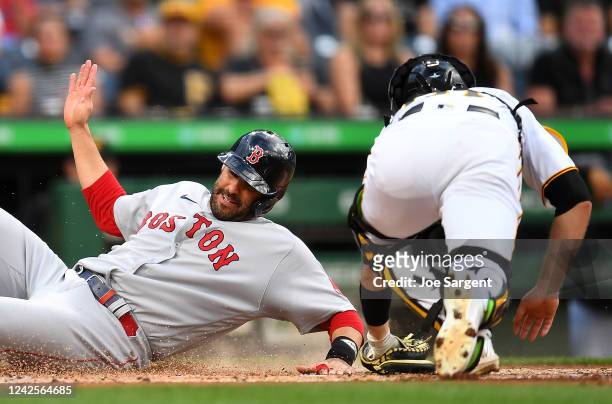 Martinez of the Boston Red Sox scores in front of Jason Delay of the Pittsburgh Pirates during the second inning at PNC Park on August 17, 2022 in...
