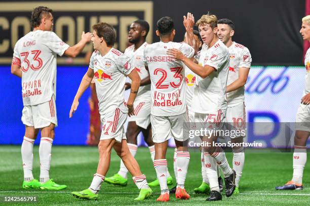 Teammates surround New York midfielder Lewis Morgan after his first-half goal during the MLS match between the New York Red Bulls and Atlanta United...