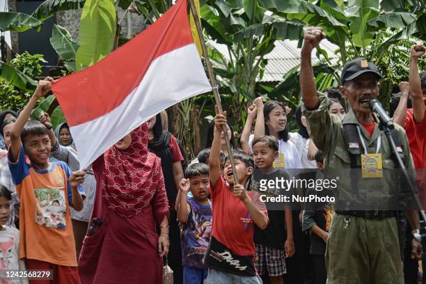 Residents gesturing as they attend during a ceremony to mark the 77th Indonesian Independence Day in Bogor, West Java, Indonesia, on August 17, 2022.