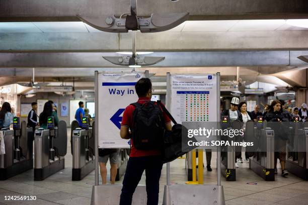 At Westminster underground station a traveler reads an announcement about potential disruption to services due to strike action, London and the rest...