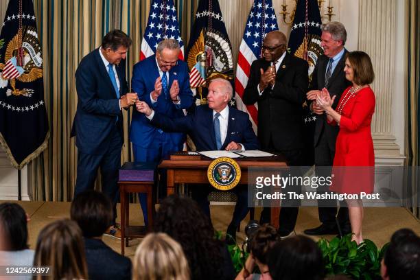 August 16, 2022: US President Joe Biden hands Sen. Joe Manchin the pen used to sign into law H.R. 5376, the Inflation Reduction Act of 2022 in the...