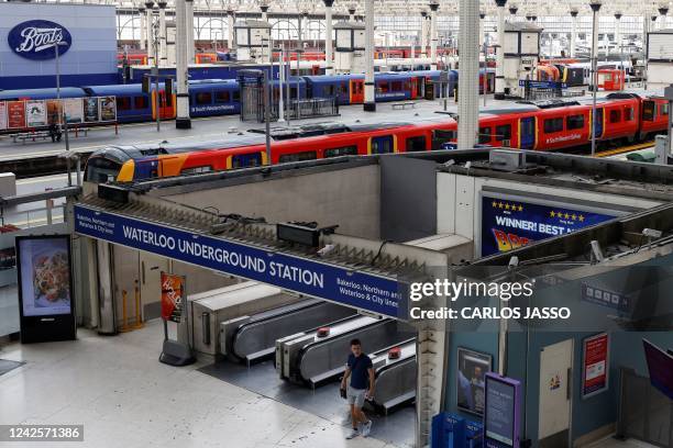 Lone commuter walks at Waterloo Station in London on August 18, 2022 as Britain's train network faced further heavy disruption in major walkouts that...