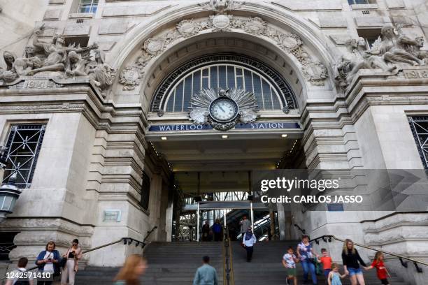 People walk in and out of Waterloo Station in London on August 18, 2022 as Britain's train network faced further heavy disruption in major walkouts...