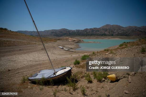 Boat that used to float on the water lies on dry land due to the effect of the drought in the La Vinuela reservoir, in the province of Malaga, on...