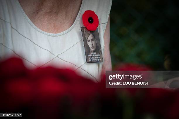 This photograph taken on August 18, 2022 shows a brooch hanged on a participant's chest holding a picture of a soldier, during the commemoration of...