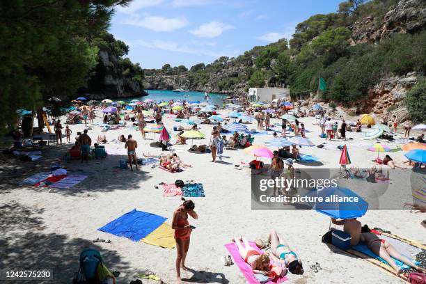 August 2022, Spain, Llucmajor: People take a sunbath at Cala Pi beach. Photo: Clara Margais/dpa