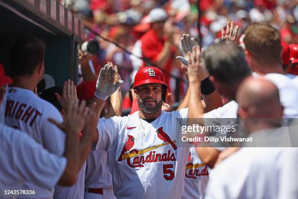 Albert Pujols of the St. Louis Cardinals his congratulated by teammates after hitting a grand slam against the Colorado Rockies in the third inning...