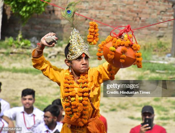 Student is dressed as Lord Krishna, as children watch other fellow students form a pyramid to break the dahi-handi, as part of celebrations on the...