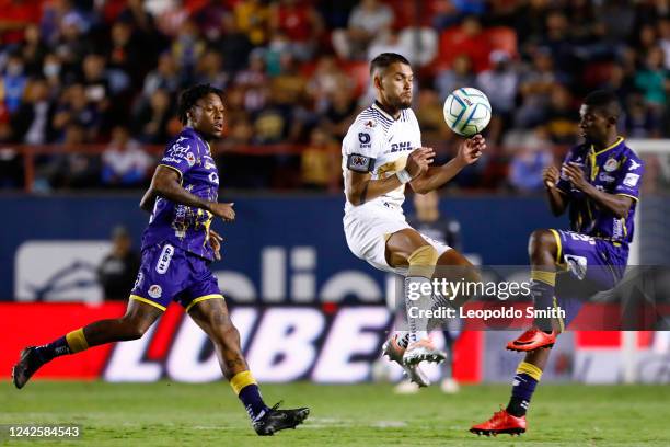 Nicolas Freire of Pumas UNAM struggles for the ball with Abel Hernandez and Vitor Ferreira of Atletico San Luis during the 9th round match between...