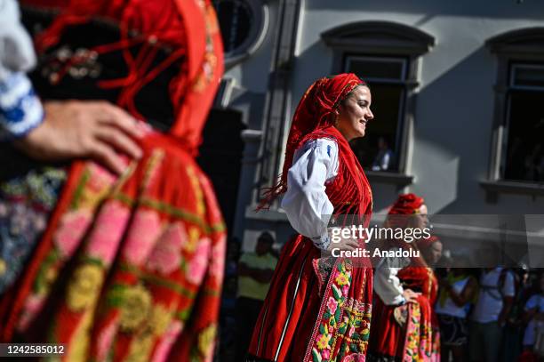 Hundreds of women dressed in traditional folk clothing from their regions walk together carrying their family gold during the Mordomia Parade part of...