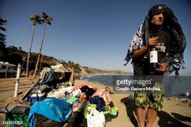 Phillip Krohn who lives homeless on a bluff above the Pacific Ocean, wears fabric to protect him from the sun along Pacific Coast Highway near Sunset...