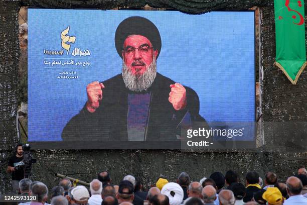 Supporters of the Lebanese Shiite Muslim movement Hezbollah attend a televised speech by the group's leader Hassan Nasrallah during a ceremony to lay...