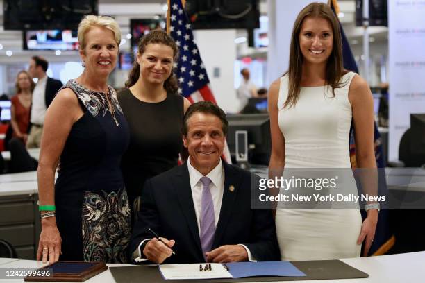 Gov. Andrew Cuomo signed the Farmworkers Fair Labor Practices Act on July 17 in New York, along with his ex-wife Kerry Kennedy, left, and daughters...