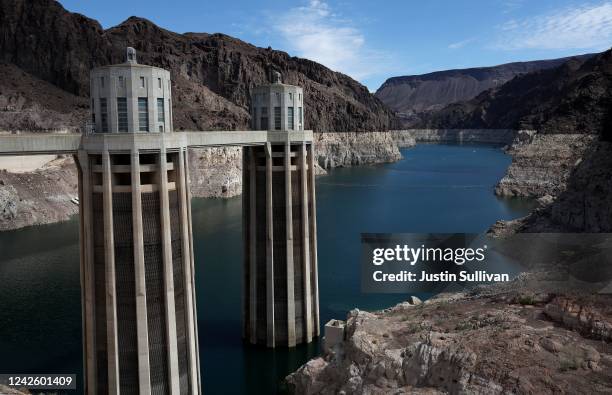 Water intake towers at the Hoover Dam stands next to a bleached "bathtub ring" on the banks of Lake Mead on August 19, 2022 in Lake Mead National...