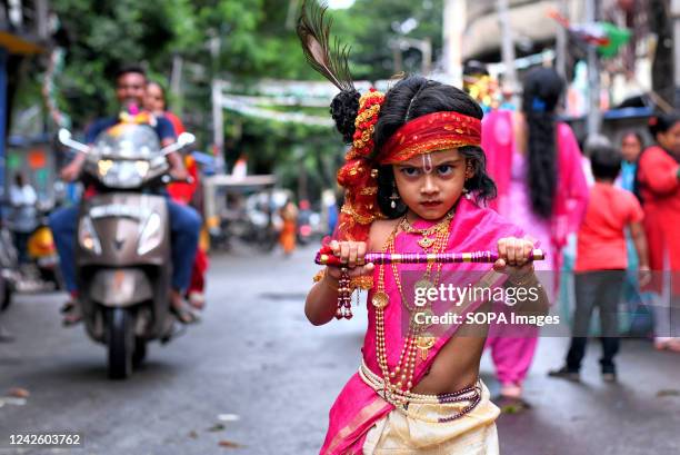 Little child dressed up as Lord Krishna poses for a photo on street during the Janmastami festival in Kolkata. Janmastami is an annual Hindu festival...