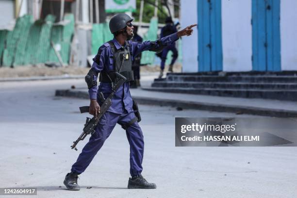 Security officer gestures as he and colleagues patrol at the the site of explosions in Mogadishu on August 20, 2022. - At least eight civilians have...