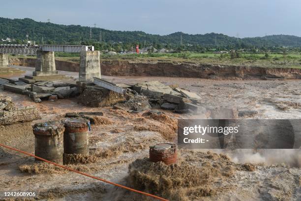 General view of the section of a railway bridge washed away by the deluge at the Chakki River after flash floods in Kangra district, in Indias...