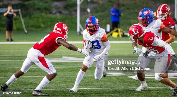 Costa Mesa, CA Gardena Serra running back Jamar Bell-Gonzalez gains yardage as Orange Lutheran cornerback Keon Washington, left, and defensive...