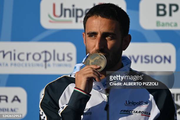 Bronze medallist Italy's Giovanni Tocci kisses his medal as he poses on the podium after competing in the Men's Diving 3m springboard final event, on...