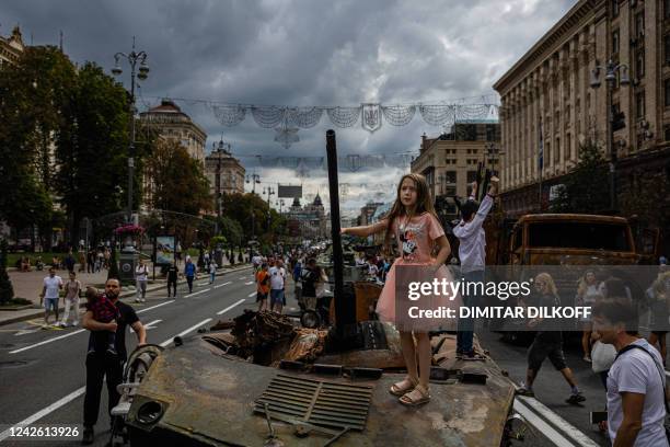 Girl stands on top of destroyed Russian military equipment at Khreshchatyk street in Kyiv on August 20 that has been turned into an open-air military...