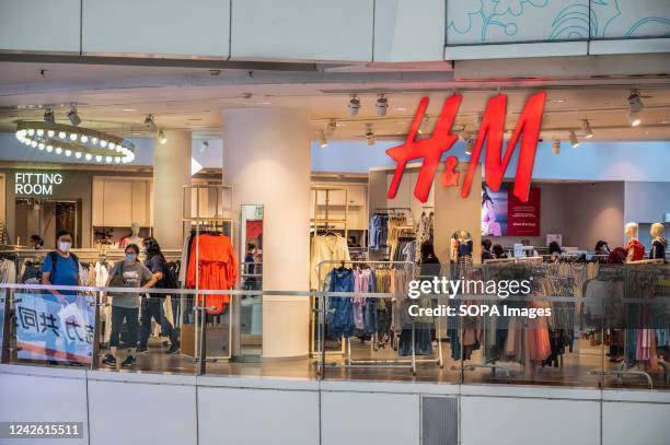 Shoppers are seen at the Swedish multinational clothing design retail company Hennes & Mauritz, H&M store in Hong Kong.