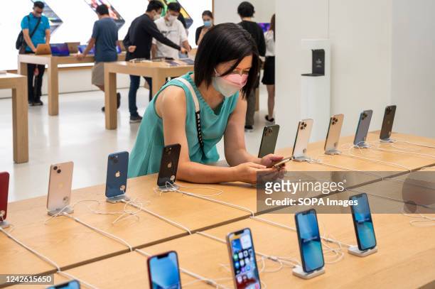 Shopper tests Apple brand products, such as the iPhone smartphone, at an Apple store in Hong Kong.
