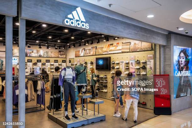 Shoppers are seen at the German multinational sportswear brand Adidas store in Hong Kong.