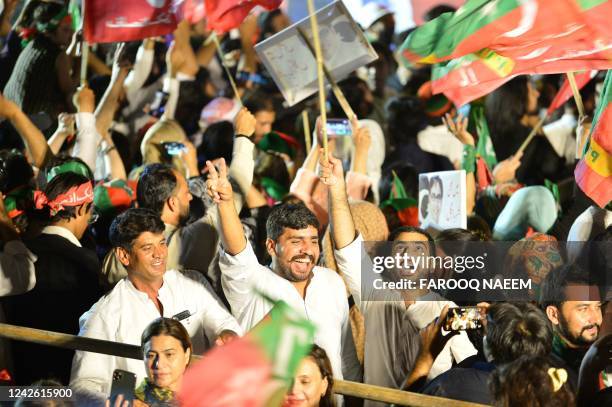 Supporters of Pakistan's former Prime Minister and leader of the Pakistan Tehreek-e-Insaf party Imran Khan, wave flags during an anti-government...