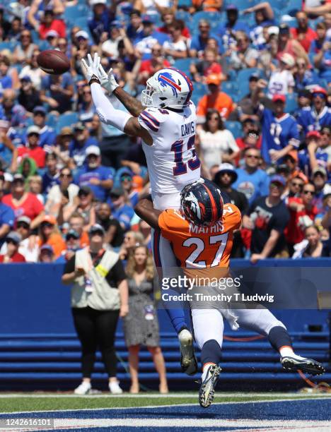 Damarri Mathis of the Denver Broncos tries to defends as Gabriel Davis of the Buffalo Bills jumps to make a catch and score a touchdown during the...