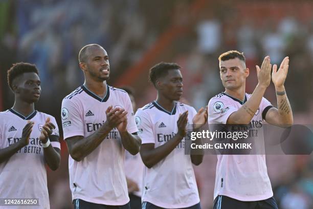 Arsenal's Scottish defender Kieran Tierney applauds as he celebrates with teammates after winning at the end of the English Premier League football...