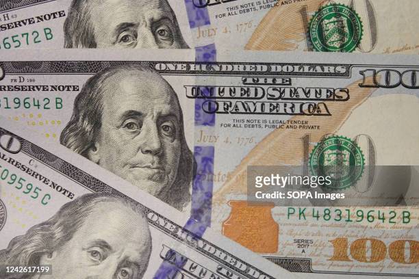 In this photo illustration, 100 dollar bills seen displayed.