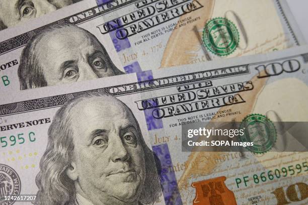 In this photo illustration, 100 dollar bills seen displayed.