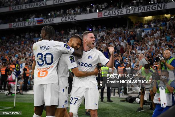 Marseille's Colombian forward Luis Suarez celebrates with teammates Marseille's Portuguese defender Nuno Tavares and Marseille's French midfielder...