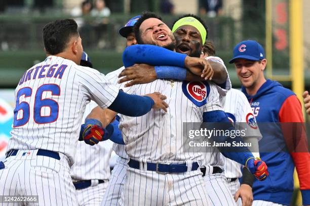 Rafael Ortega of the Chicago Cubs and Franmil Reyes surround Willson Contreras and celebrate after a Contreras walk-off single gave Chicago the 6-5...